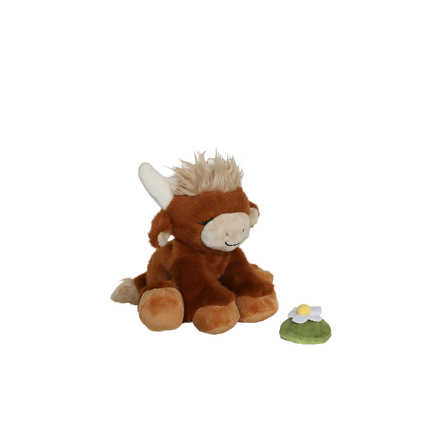 Plush toy cow with a small flower on a white background