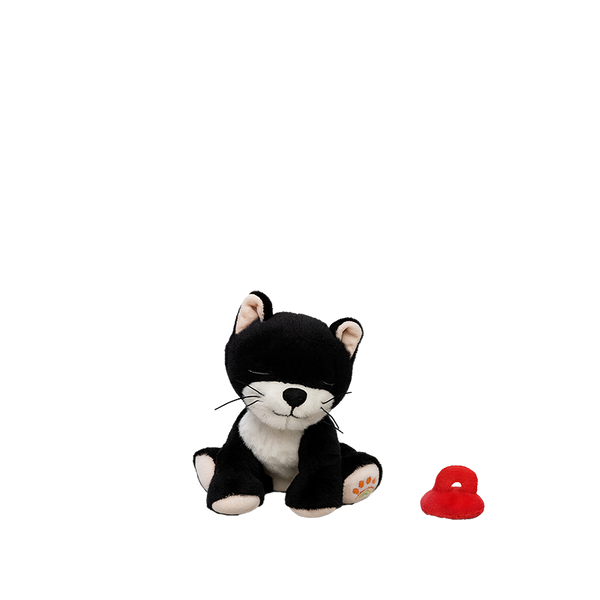 Black and white plush toy cat with a red object on a white background