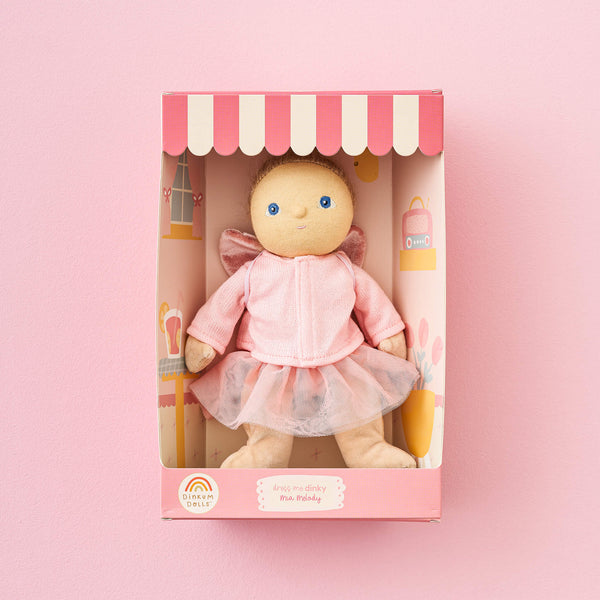 Toy doll in a pink outfit with a matching box on a pink background