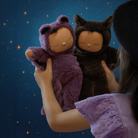 Two plush toys, one purple and one brown, held against a starry night sky.