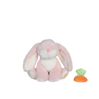 Pink plush bunny toy with a small carrot on a white background