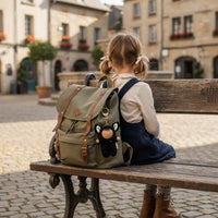 Child with a backpack sitting on a bench in an old town square