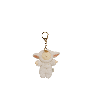 Plush keychain of a baby doll in a white outfit with gold chain on a white background
