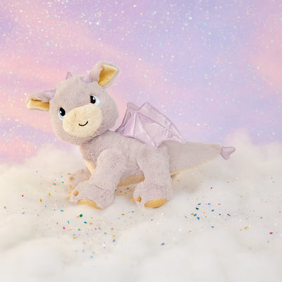 Plush dragon toy with wings on a soft, cloud-like surface with a pastel background