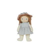 Stuffed doll with a pink hat and light blue dress on a black background