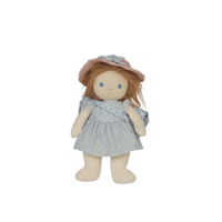 Stuffed doll with a blue dress and pink hat on a black background