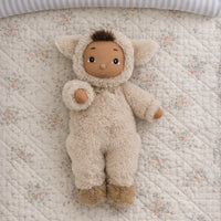 Stuffed animal toy in a fluffy outfit on a floral quilted surface