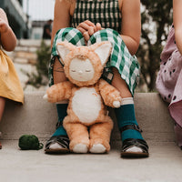 Little girl sitting with her ginger tabby cat, soft plush toy dinkum doll for kids