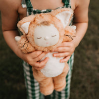 Little girl holds her ginger tabby cat, soft plush toy dinkum doll for kids