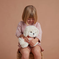 Olli Ella Dinkum Dog Cookie - Chien blanc, harnais rose tenu par l'enfant