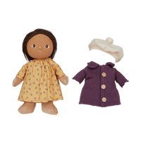 Doll with yellow dress and brown hair, purple coat, and white hat on a white background
