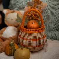 Olli Ella Halloween Berry Basket with orange stripe holding pumpkin