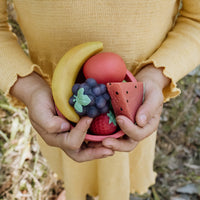 Olli Ella Tubbles Sensory Stones Fruit Fantastique tenu dans les mains des enfants