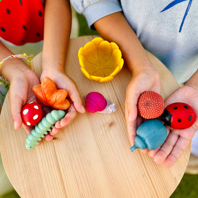 Olli Ella Tubbles Sensory Stones Garden Goodies tenus dans les mains des enfants