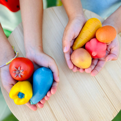 Olli Ella Tubbles Sensory Stones Vibrant Légumes tenus dans les mains des enfants
